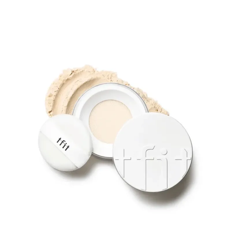 Offene Dose mit TFIT Translucent Set Finishing Powder in der Nuance Skin Beige, mit beiliegendem Puff und puder darum herum verstreut.